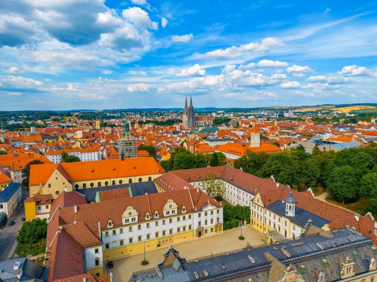 Luftaufnahme einer historischen Stadt mit roten Dächern.