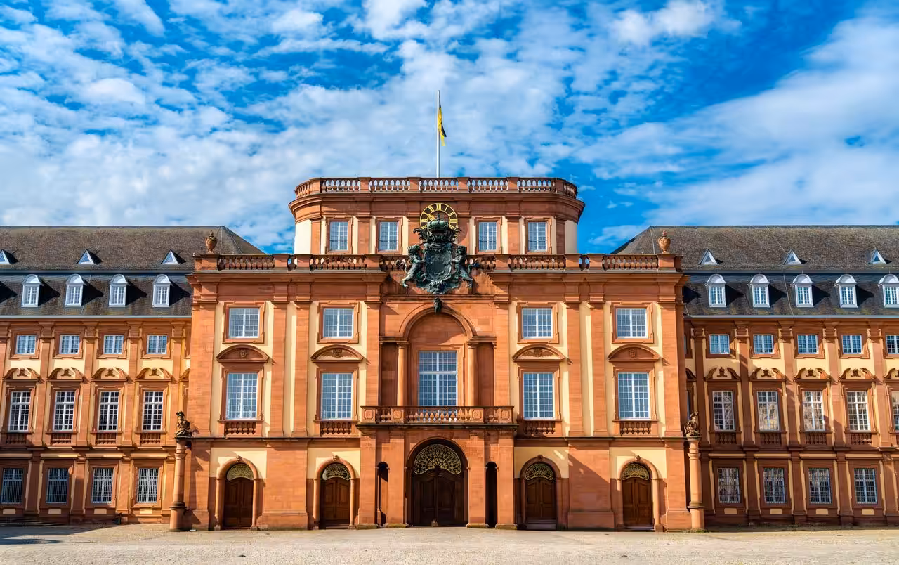 Barockes Schloss mit Sandsteinfassade und Wappen.