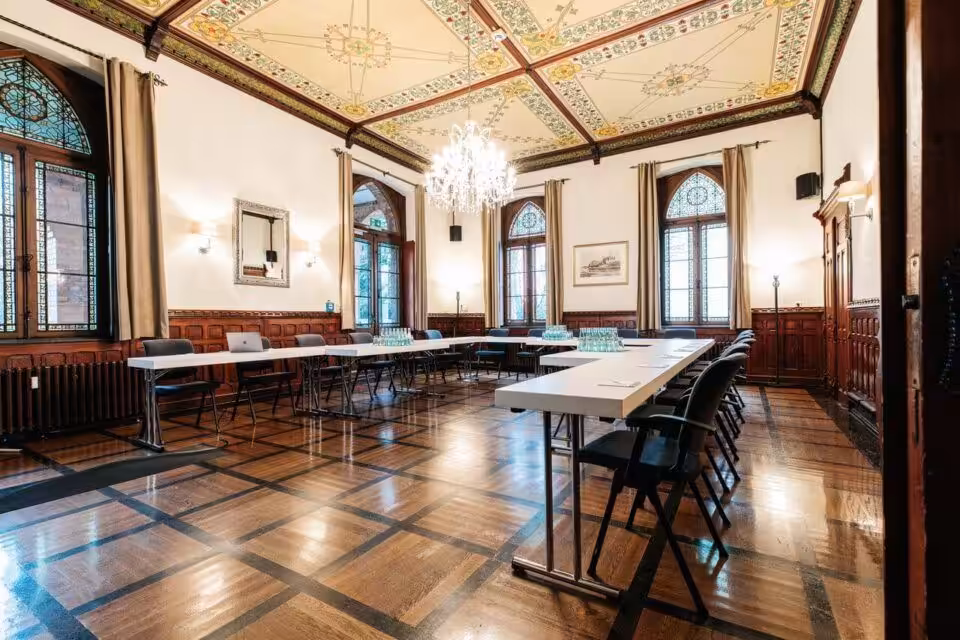 Historischer Veranstaltungsraum mit dekorativem Deckenmuster