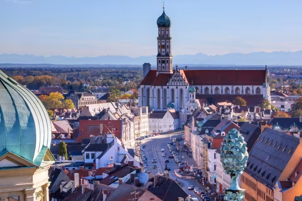 Stadtblick auf Augsburg mit Kirche und Berge.