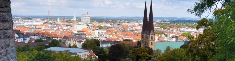 Panorama von Bielefeld mit Kirchtürmen und Häusern.