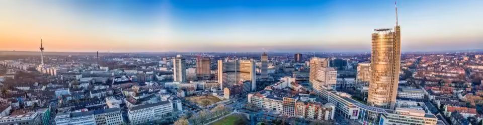 Panoramaaufnahme der Düsseldorfer Skyline bei Sonnenuntergang.